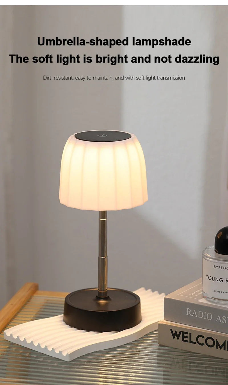 Cordless LED lamp with umbrella-shaped white shade on metal stem and round base