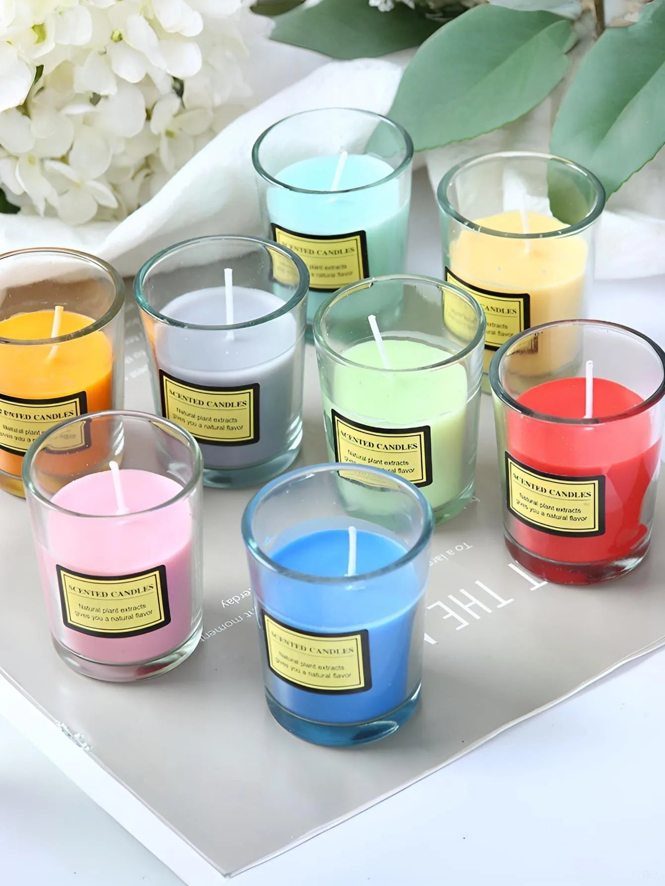Scented candle trio in clear glass jars with pink, green, blue, yellow, and red wax