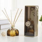 Reed diffuser bottle with light wooden reeds and white woven ball, in gift box