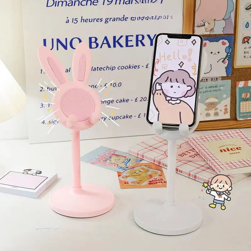 Blush pink rabbit phone stand with circular mesh face, upright ears, and raised phone platform