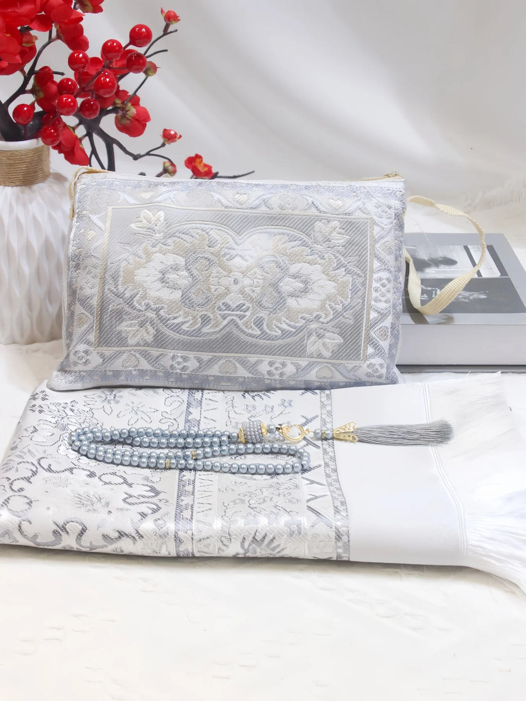 Prayer rug gift set with silver pouch, grey patterned mat, and grey beaded tassel strand