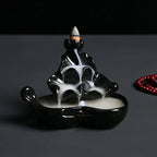 Black glossy backflow incense burner shaped like a hand holding a cone incense stand