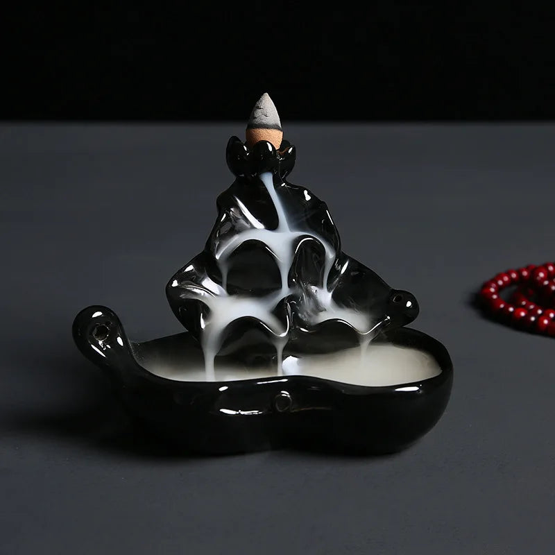 Black glossy backflow incense burner shaped like a hand holding a cone incense stand