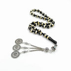 Tasbih bracelet with black and gold striped beads and three silver medallion charms