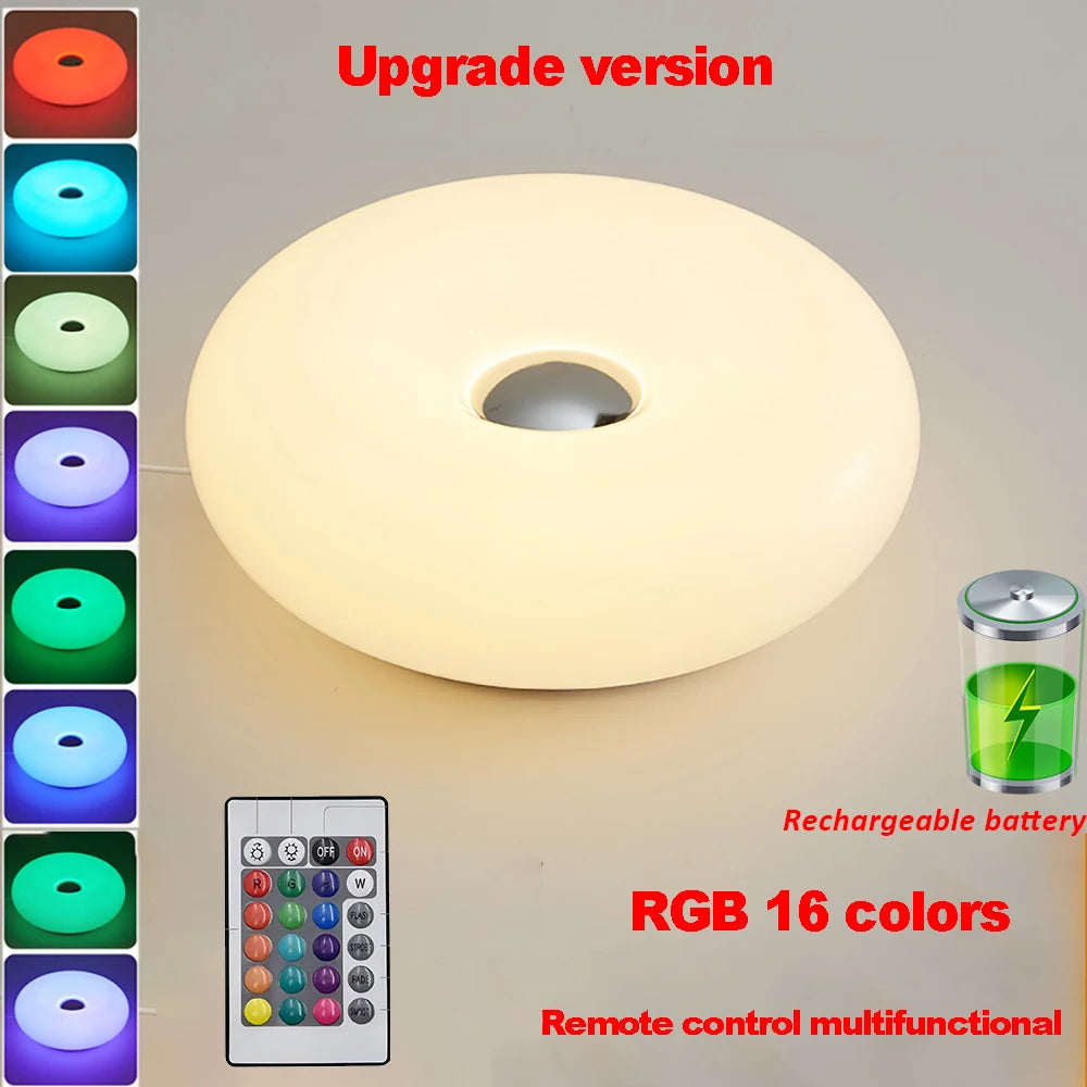 White donut table lamp glowing, with remote control and rechargeable battery icon.