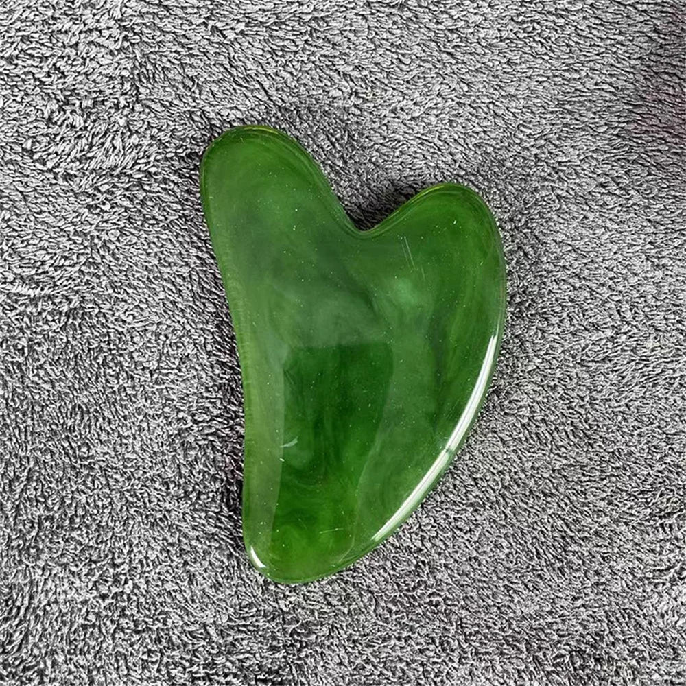 Green gua sha stone with smooth heart shape and glossy polished surface