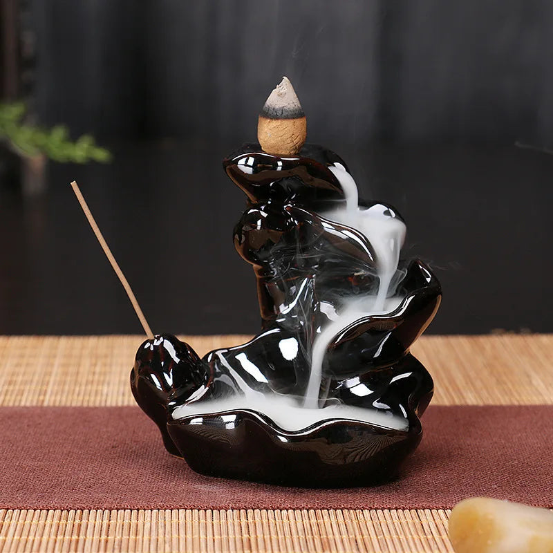 Black glossy backflow incense tower burner with a small cone incense at center