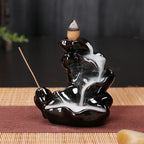 Black glossy backflow incense tower burner with a small cone incense at center