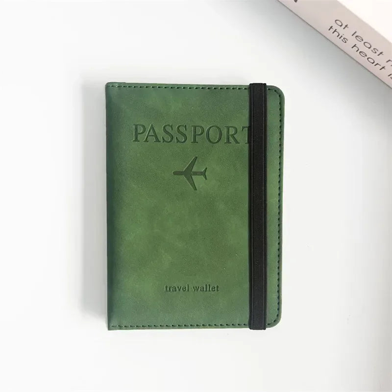 Olive green passport wallet with airplane emblem, stitched edges and side strap closure