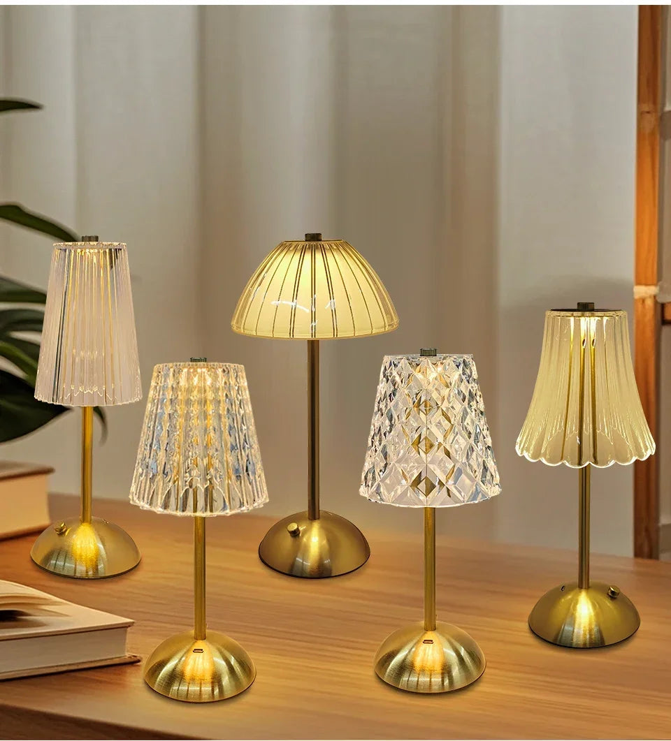 Group photo of cordless night lamps with golden and clear shades on wooden surface