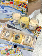 Coffret ouvert de bougies parfumées 190 g en verres, flammes allumées visibles.
