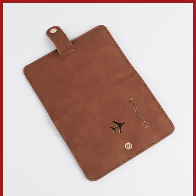 Cognac brown passport folio with airplane emblem, top handle tab, stitched corners