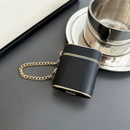 Obsidian dark wrist strap AirPods case with gold chain and bottom cutouts.