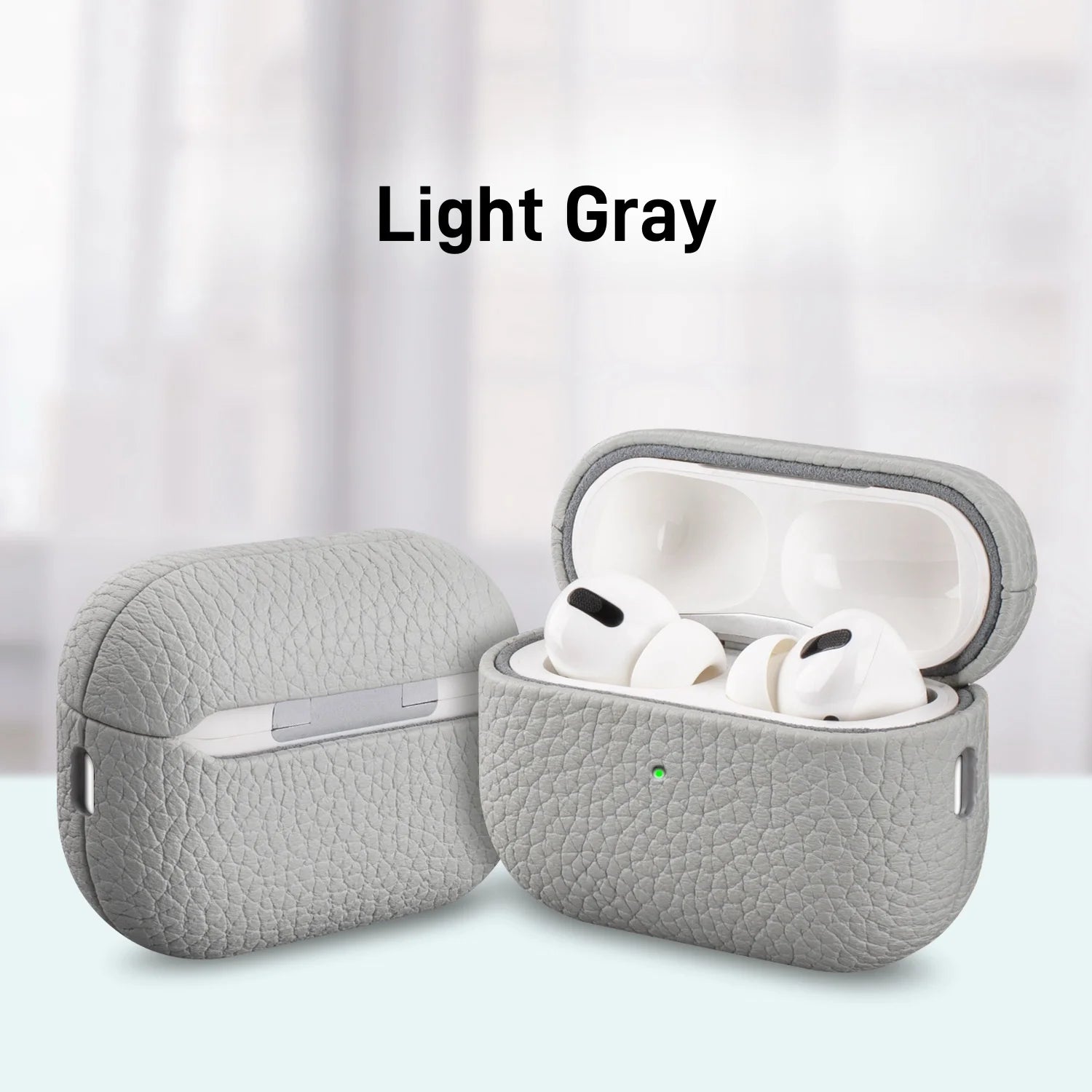 Light gray MagSafe leather AirPods case with earbuds inside, lid open