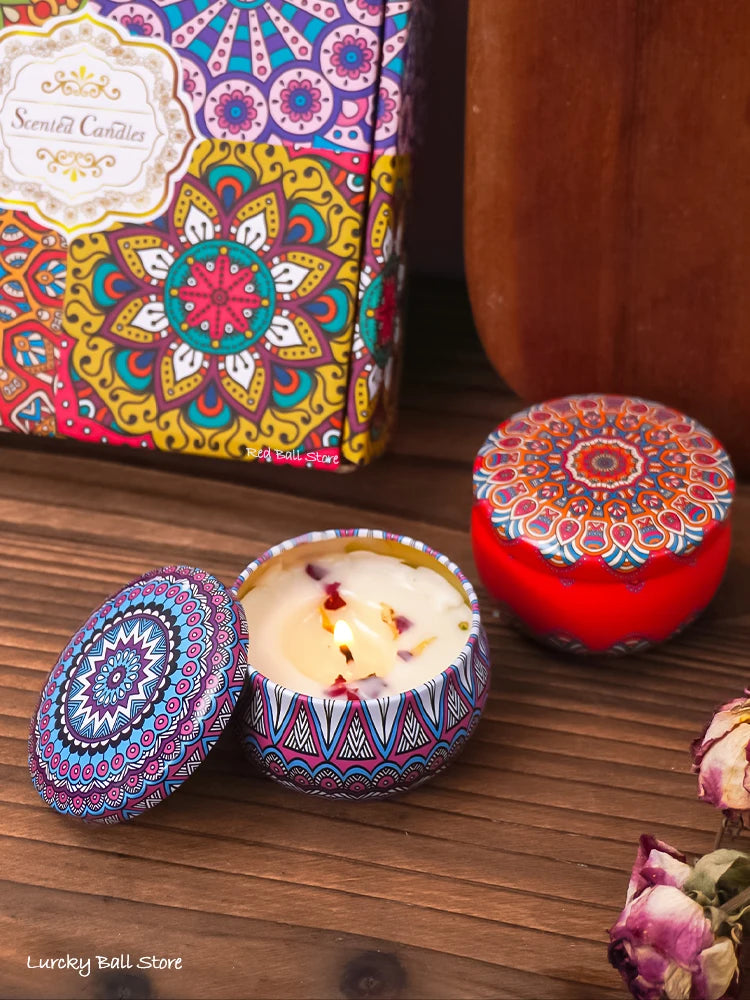 Open gift box with scented candle tins; lit candle in blue patterned holder