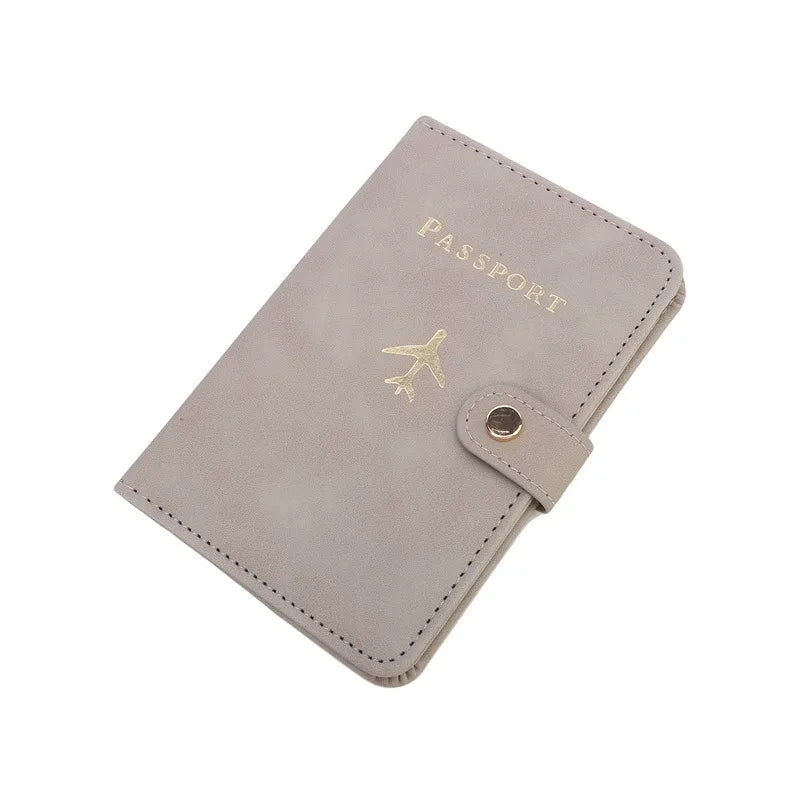 Slate grey passport cover with airplane emblem, “PASSPORT” text, and side snap closure