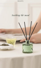 Small 50ml reed diffuser bottle with dark rattan reeds on a tabletop