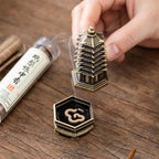 Gold pagoda-style incense holder with ornate top and hexagonal base