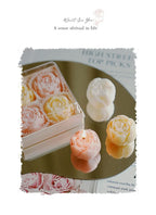 Rose-scented candle gift box with pastel rose candles and one lit candle