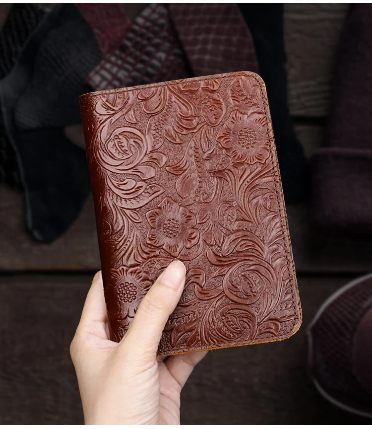 Cognac brown embossed leather travel folio held in hand, floral design