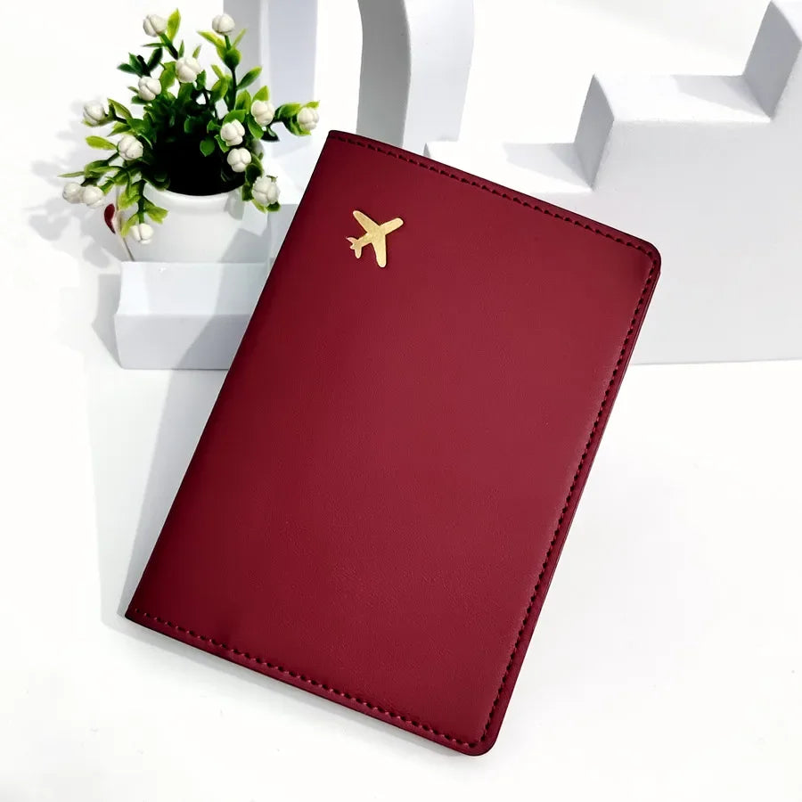 Cardinal red passport sleeve with gold plane logo and stitched edges