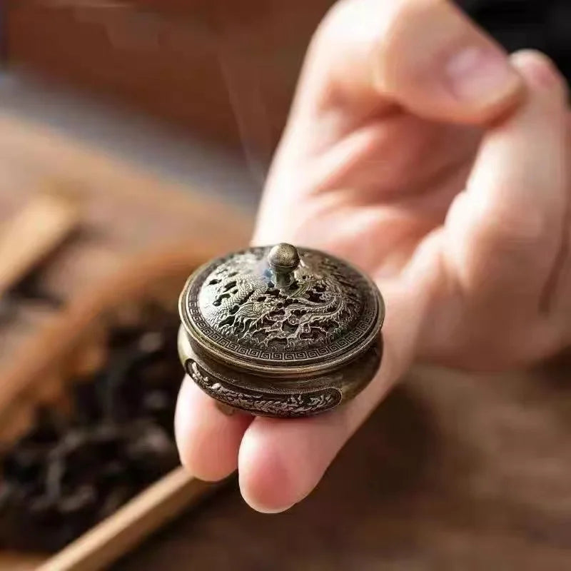 Hand holding engraved incense plate lid with raised knob detail