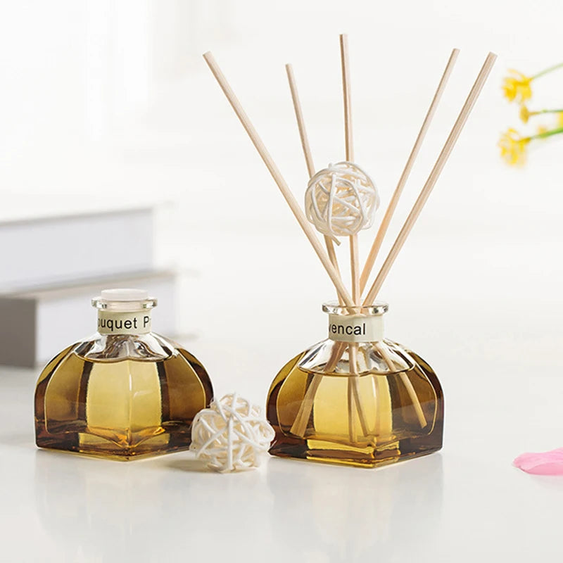 Amber reed diffuser bottles set with white rattan-style diffuser balls and 10 reeds