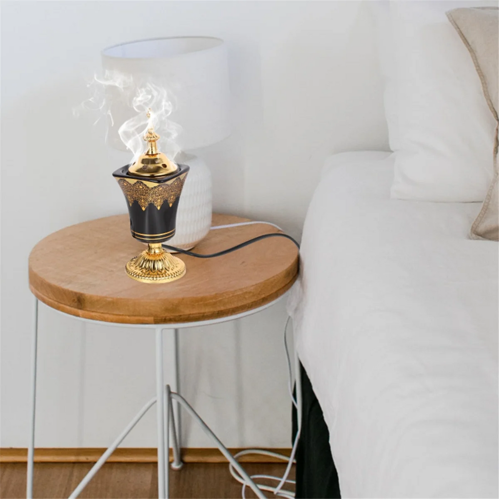 Elektrischer Räucherstövchen mit Rauch, goldene Spitze und schwarzer, goldverzierter Schale