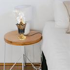 Elektrischer Räucherstövchen mit Rauch, goldene Spitze und schwarzer, goldverzierter Schale