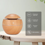 Wood-grain air humidifier diffuser on a shelf, round body with domed mist top and button.