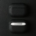 Obsidian black handmade leather AirPods case with AirPods exposed