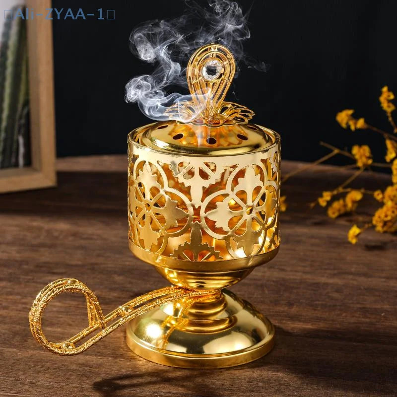 Arabesque incense burner, gold-toned pierced cylinder and decorative lid with rising smoke