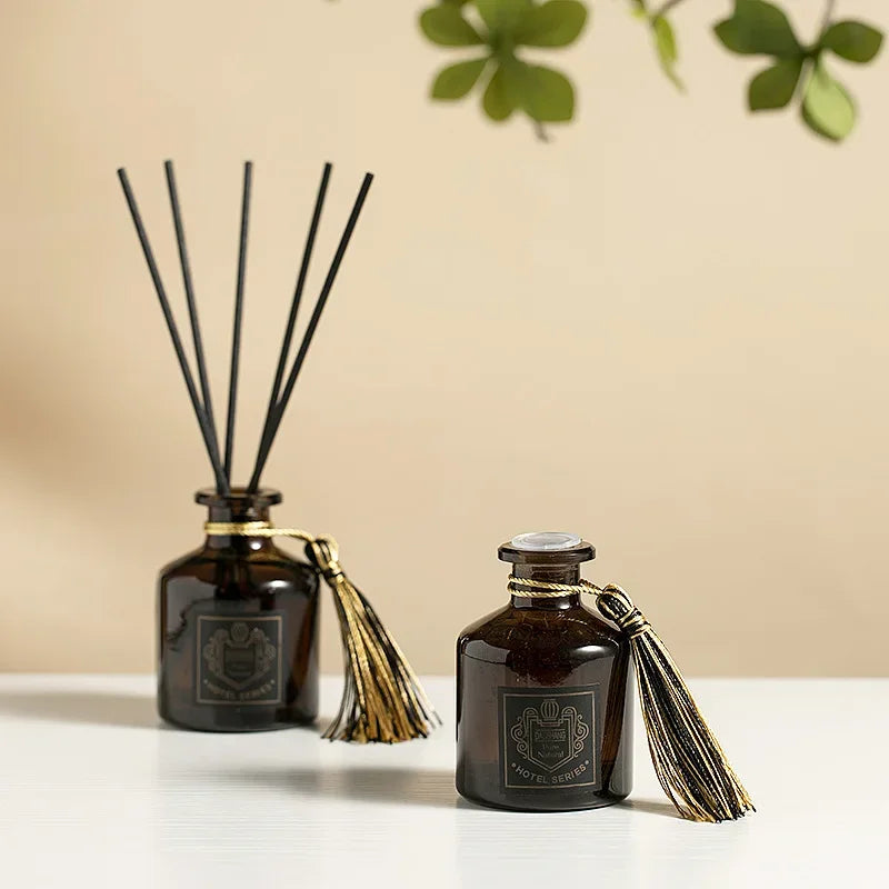 Two reed diffusers 50ml in dark glass, black reeds with gold tassel ties