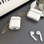 White wrist strap AirPods case with gold chain; white earbuds on display.