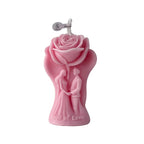 Pink rose-shaped candle figure with “God of Love” text and wick