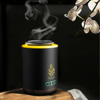 Electric bakhoor burner in dark finish with glowing yellow top ring and smoke
