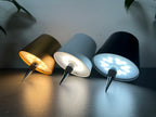 Three wireless wine bottle LED lamps with black and blue shades glowing