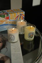 Lit French Botanical candle jars on a box, YP RÈS and pale yellow FIGUIER labels