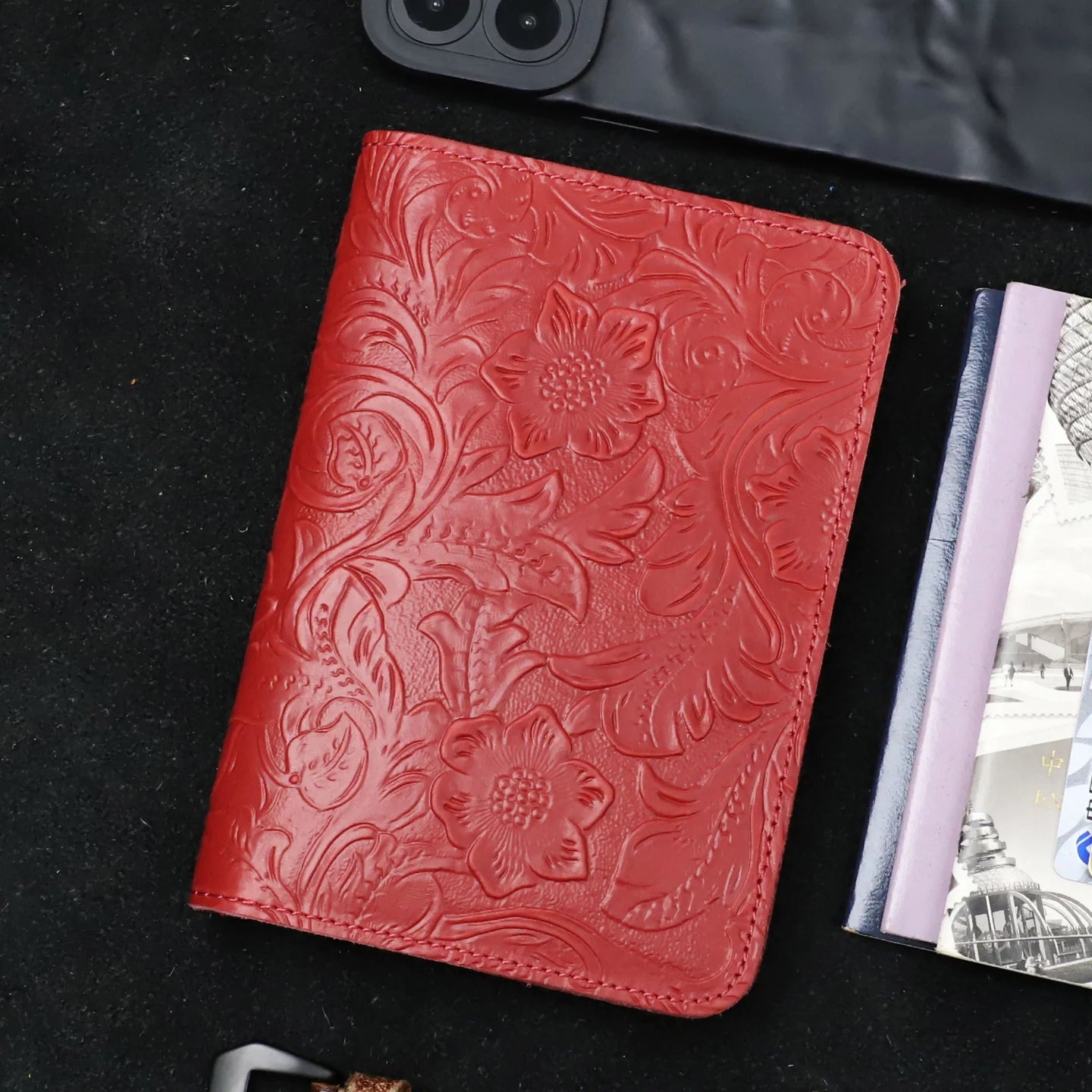 Red leather travel folio with embossed floral pattern, square corners, stitched edge