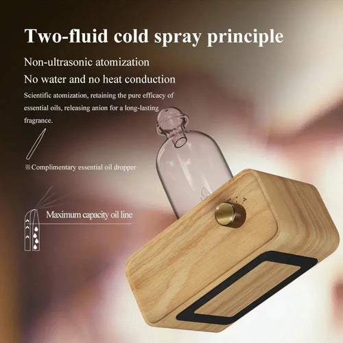 Essential oil diffuser with clear glass bottle on angled light wood base and brass button switch