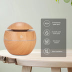Wood-grain air humidifier diffuser on a light shelf, round body with domed mist top.