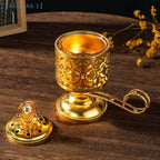 Arabesque incense burner in gold with pierced sides, wide base, and curved carrying handle