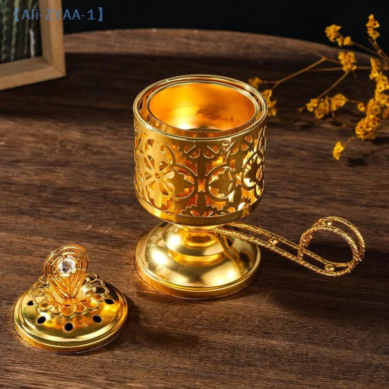 Arabesque incense burner in gold with pierced sides, wide base, and curved carrying handle