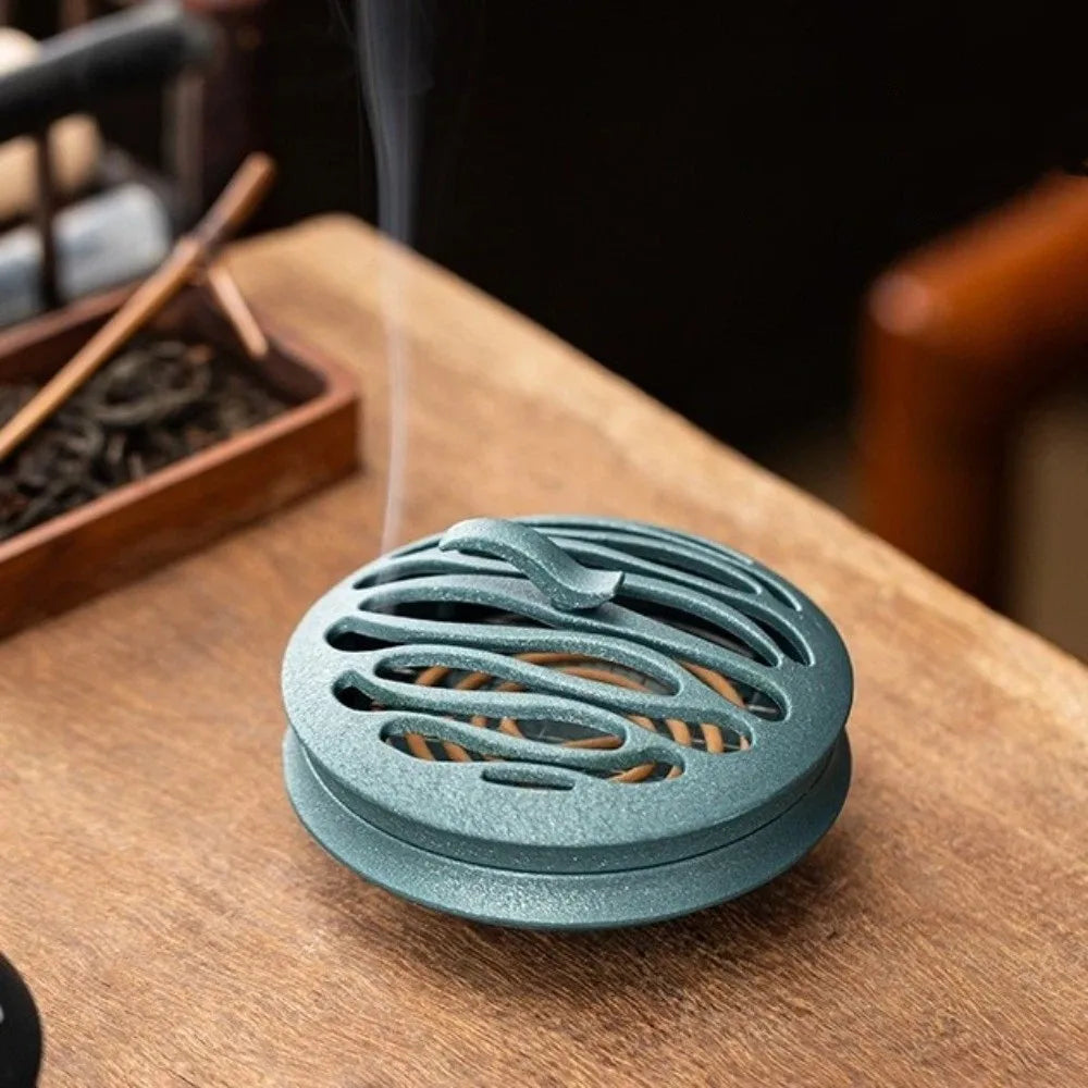 Blue hollow incense burner with oval slotted vents on tabletop