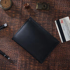 Obsidian black passport wallet with stitched edge and smooth front cover, top view