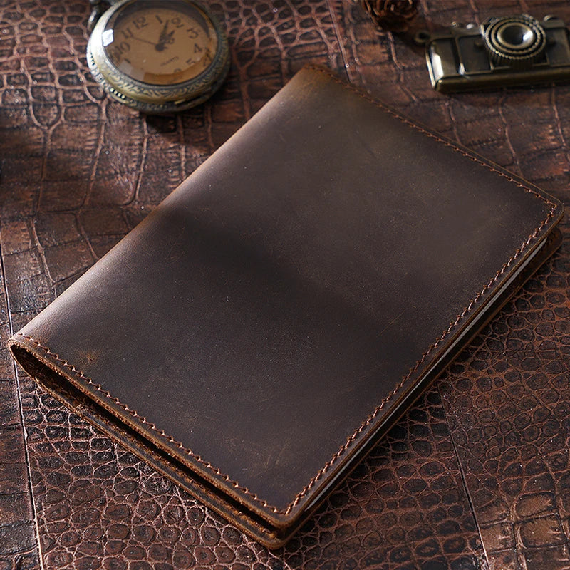 Cognac brown passport wallet closed with stitched border and smooth front panel, top view