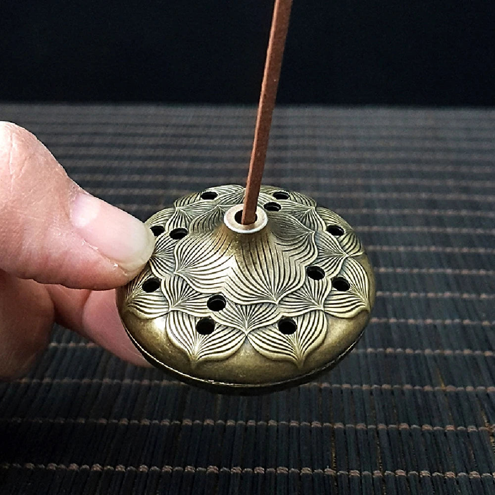 Brass pocket incense burner lid with leaf-and-flower perforation pattern and incense stick