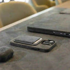 Alcantara MagSafe wallet card holder on phone, dark textured material with top flap