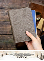 Slate grey embossed leather travel folio with floral relief, hand holding