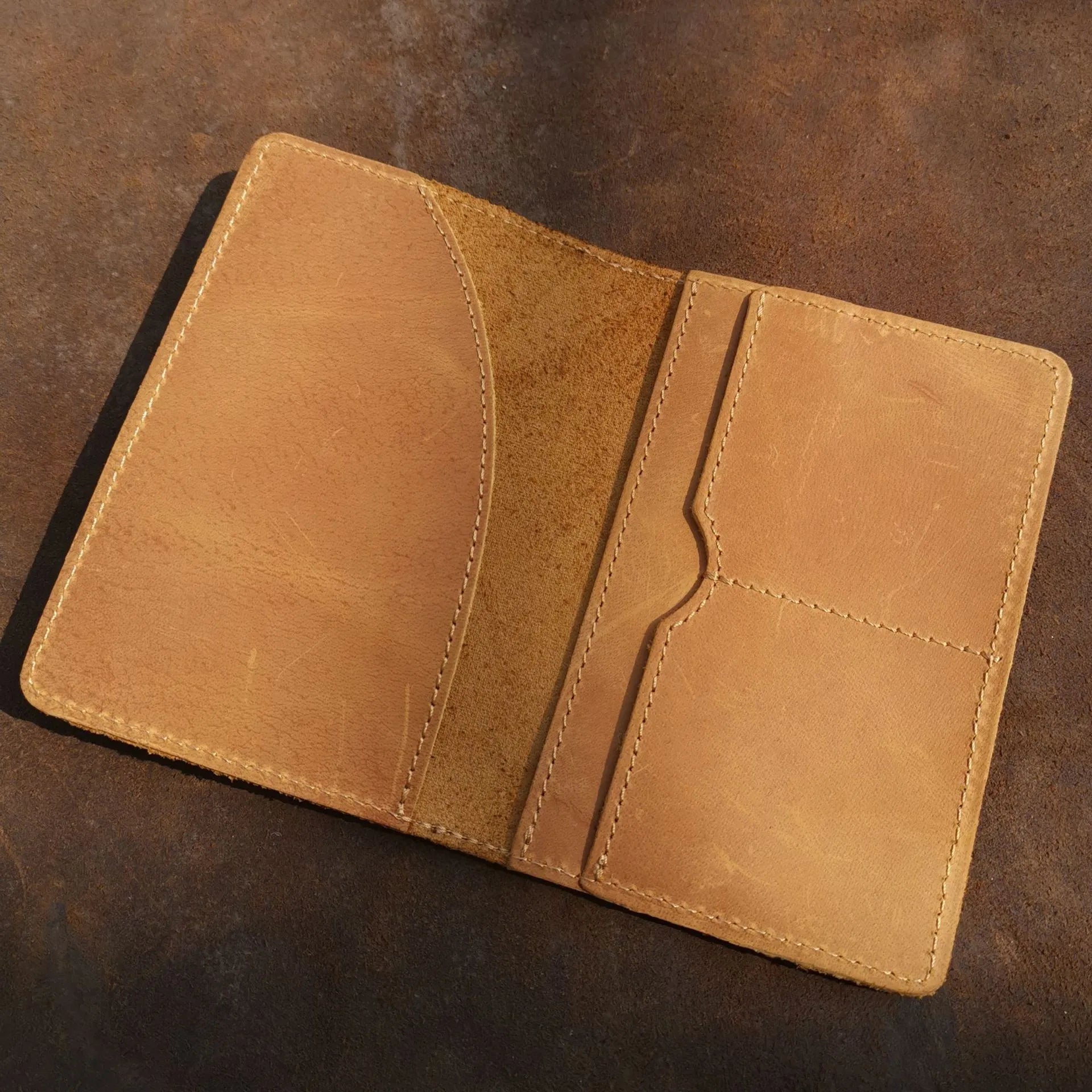 Leather passport cover with lighter tan interior panels and stitched pocket sections